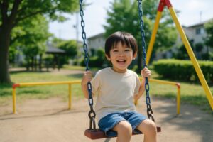 ブランコに乗って笑顔を見せる男の子