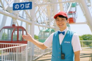 観覧車を紹介する笑顔の男性スタッフ