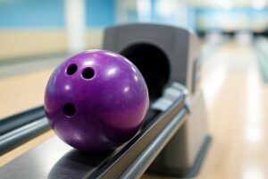 レーンに置かれた紫色のボウリングボールのクローズアップ