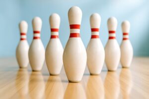 明るい室内に並ぶ赤ライン入りのボウリングピン