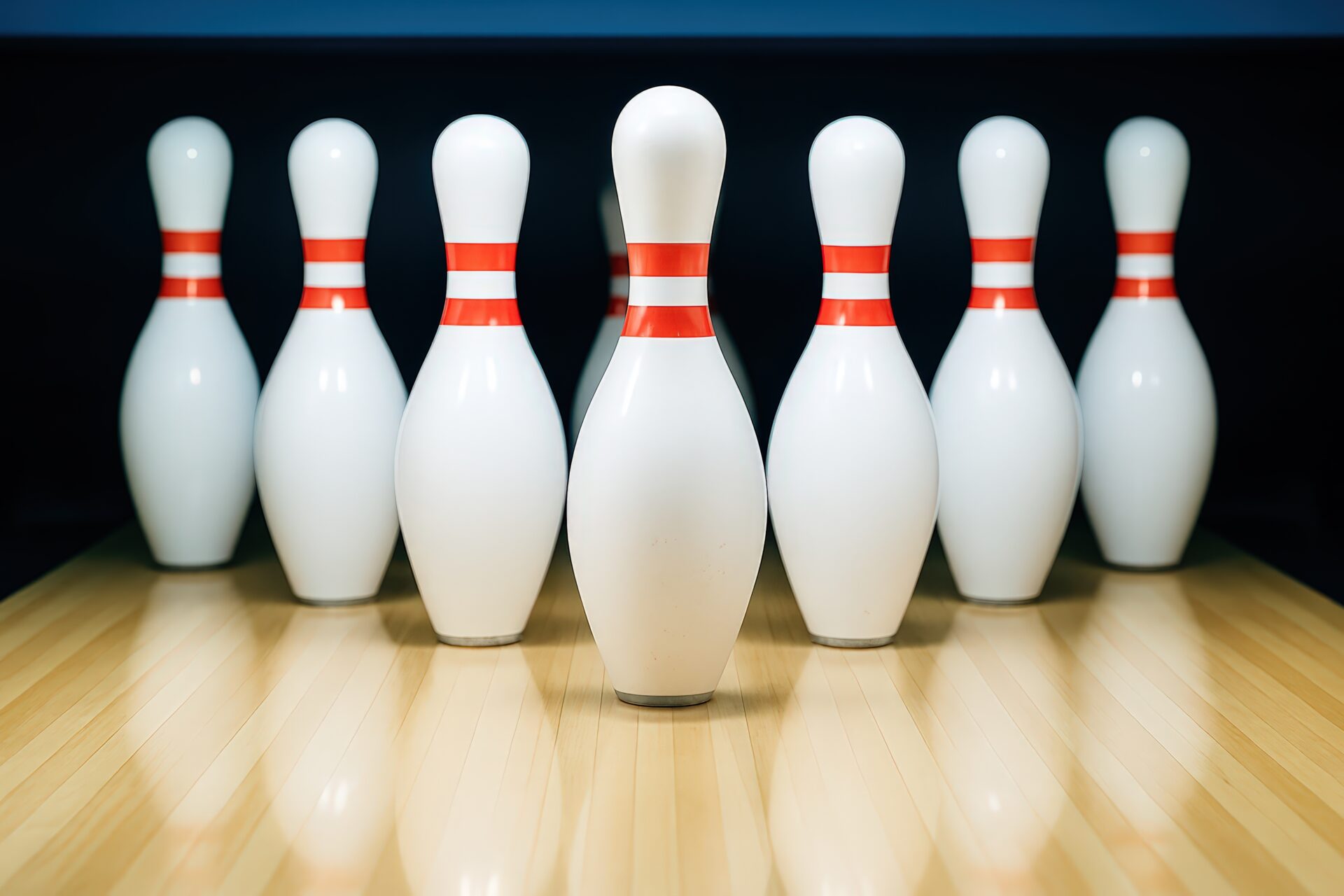 暗い背景に浮かび上がるボウリングピンの整列