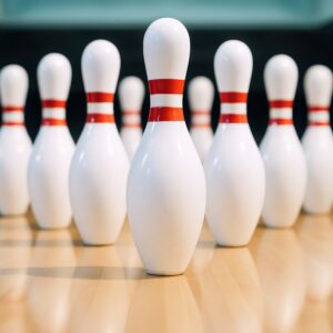 木目のレーンに立つ光沢のあるボウリングピン