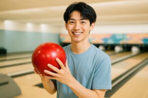 赤いボールを持ってポーズをとる笑顔の若い男性