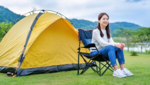 キャンプ場で黄色いテントの前に座る女性