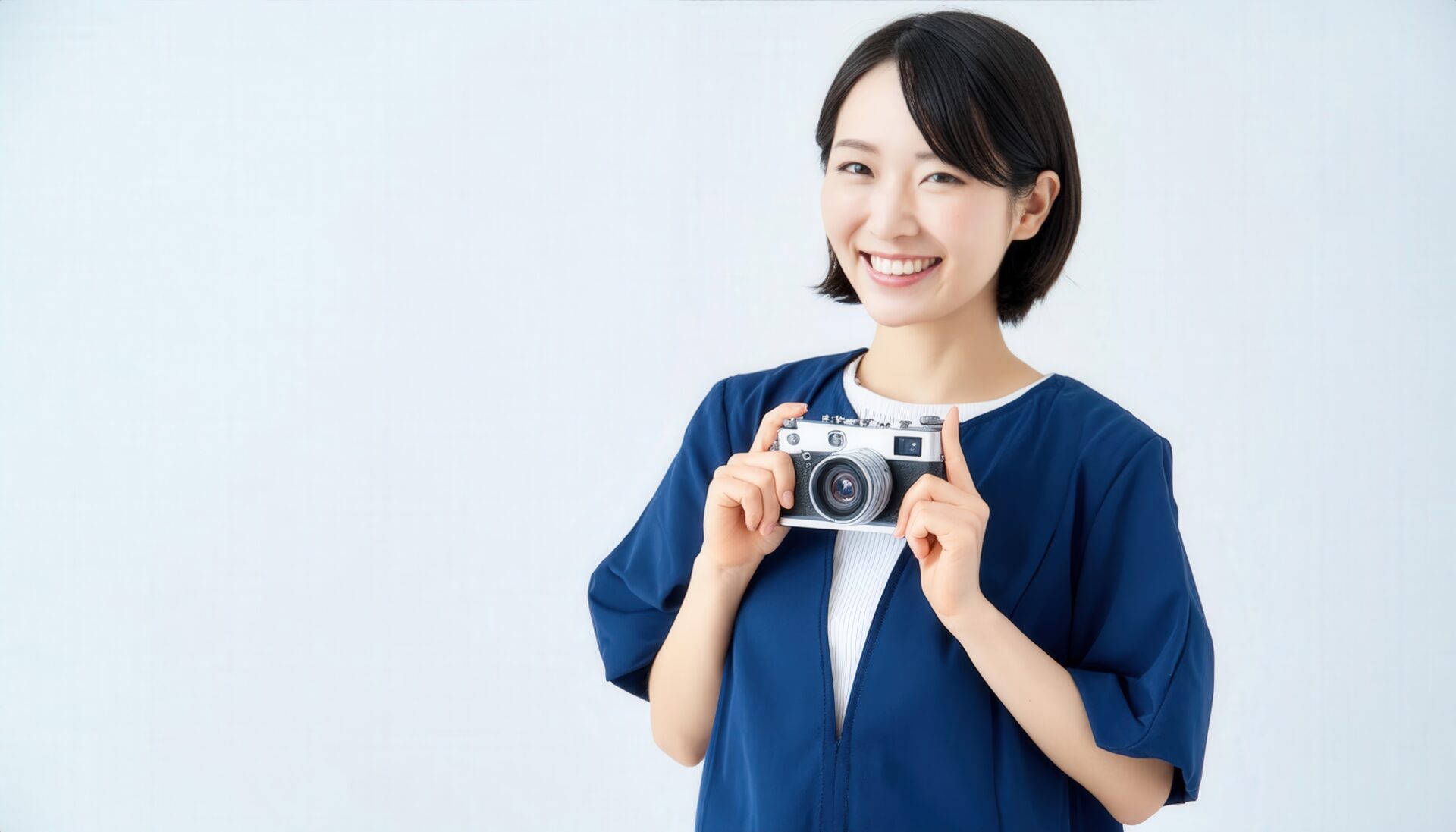 カメラを持って笑顔の女性（紺の服）