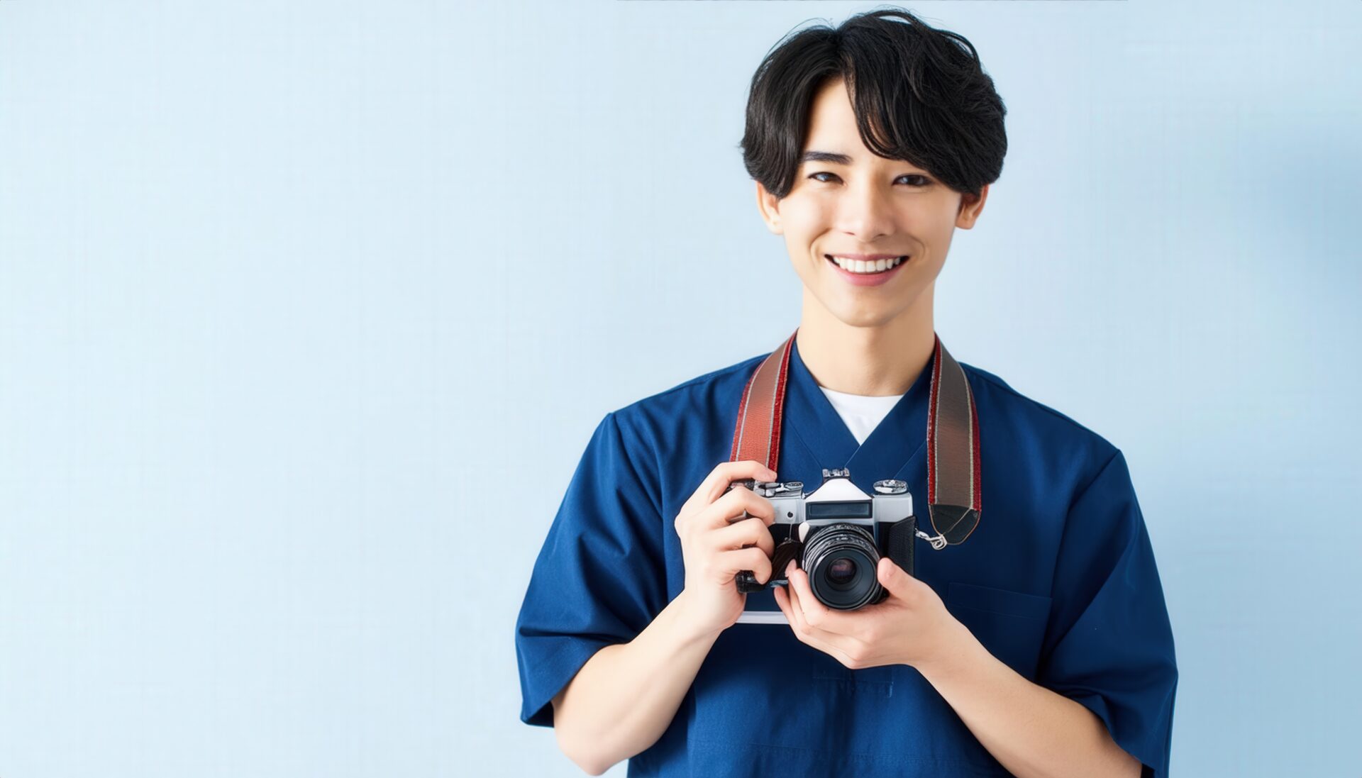 カメラを持って笑顔の男性（青い服）