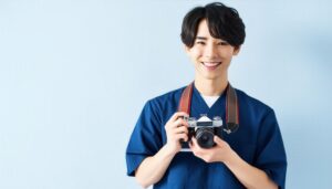 カメラを持って笑顔の男性（青い服）