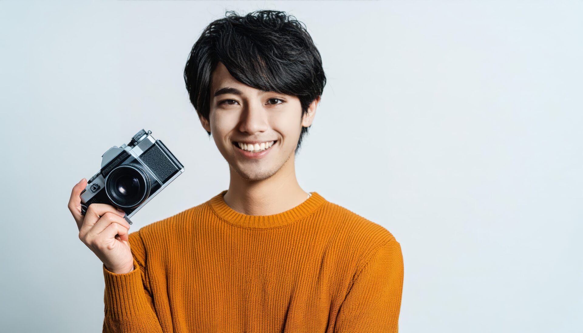 カメラを持って笑顔の男性（オレンジの服）
