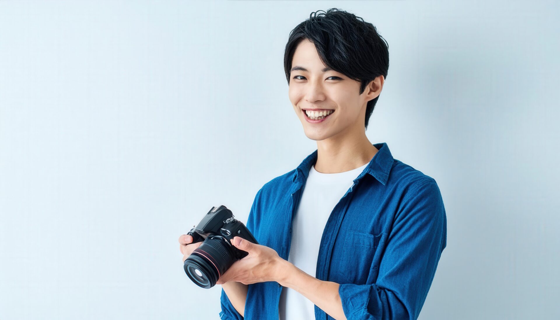 カメラを持って笑顔の男性（デニムシャツ）