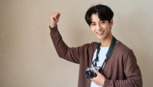 カメラを持ってガッツポーズをする男性