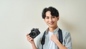 カメラを持つ男性の笑顔（室内）