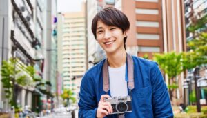 街中でカメラを持つ男性の笑顔