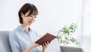 本を読む女性（ストライプシャツ）