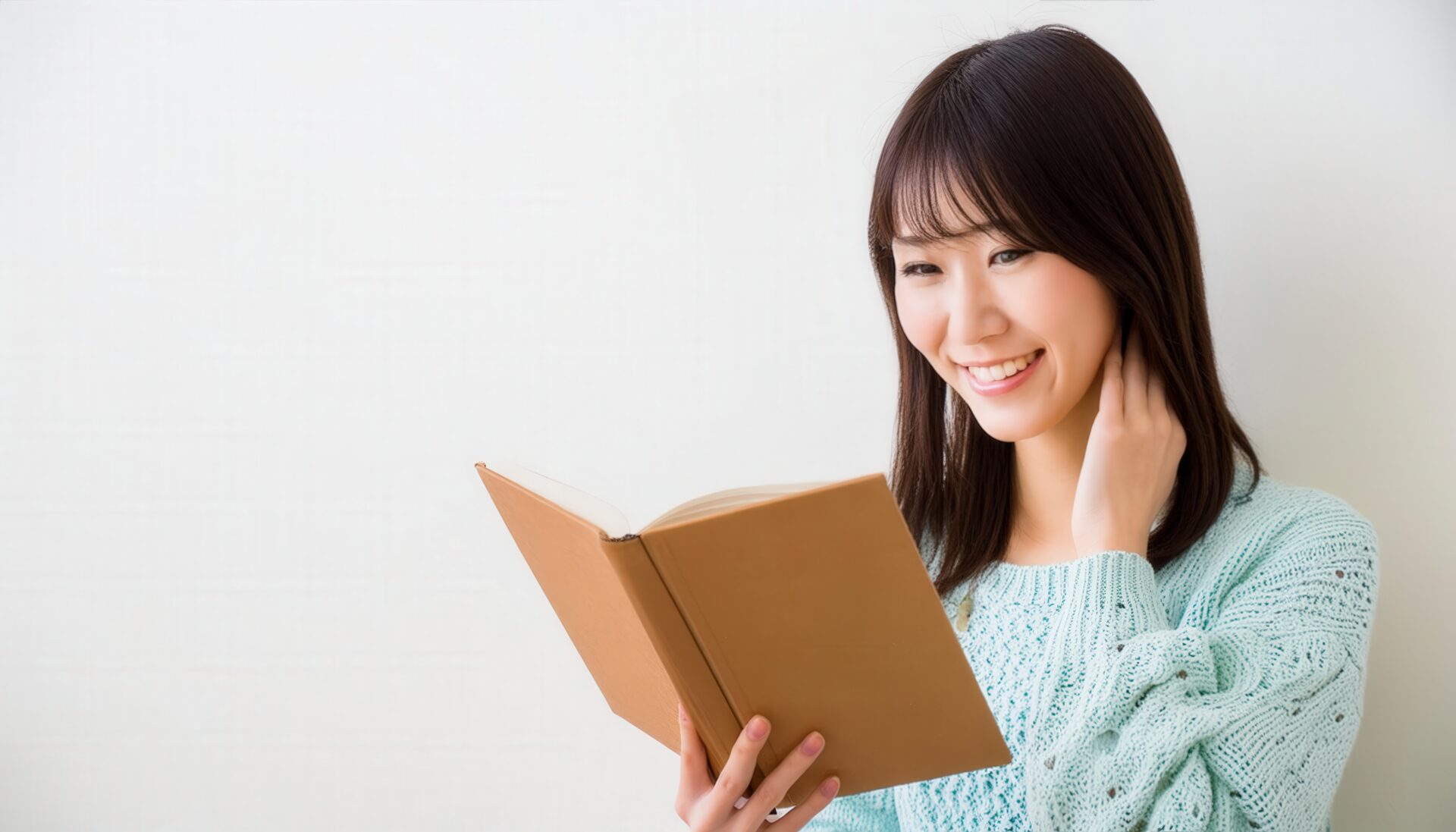 本を読む女性（ミントグリーンのセーター）