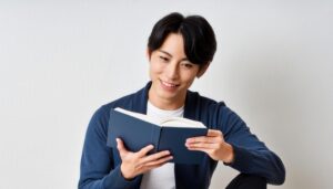 本を読む男性（青いカーディガン）