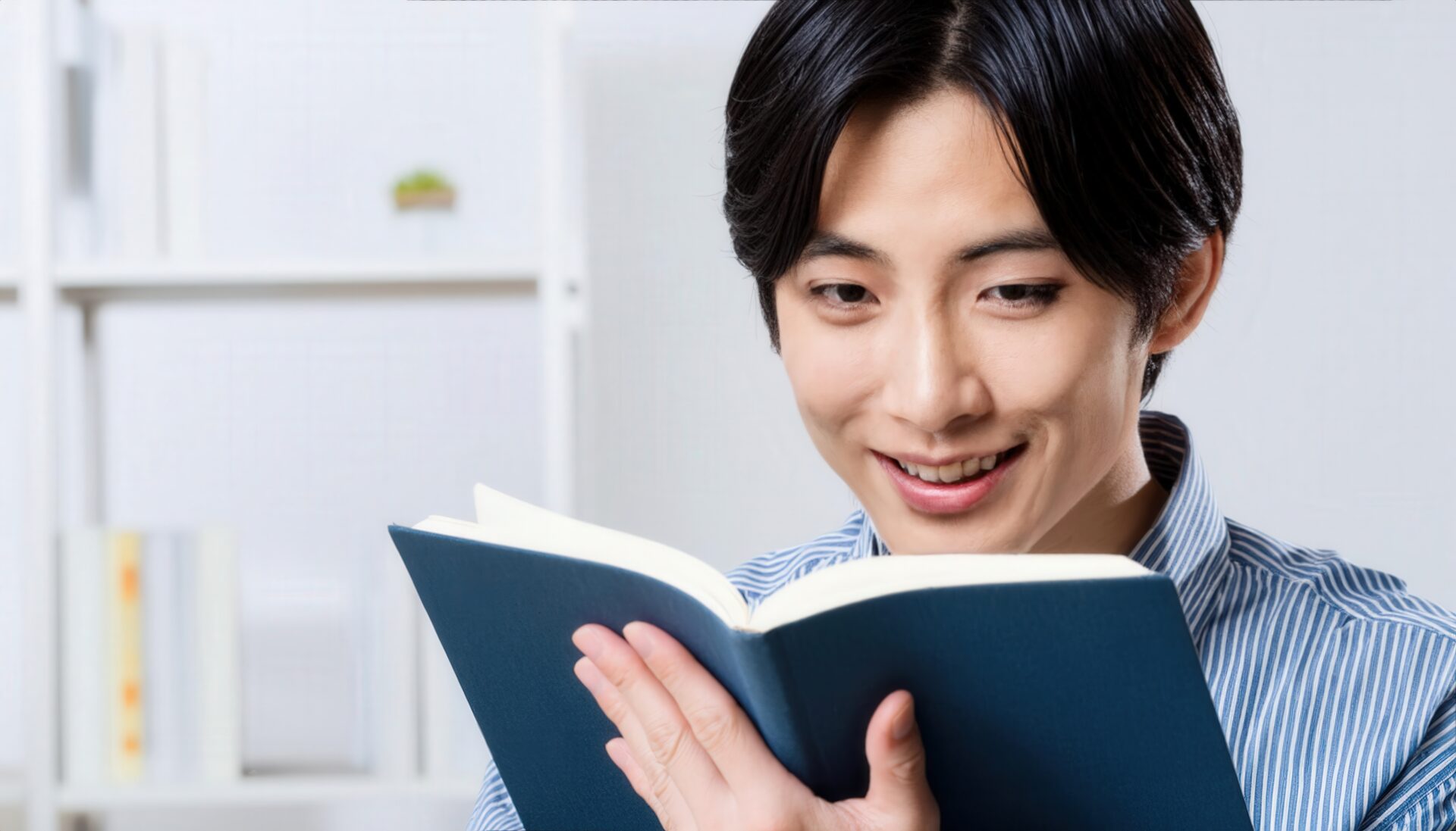 本を読む男性（ストライプシャツ）