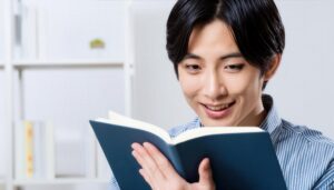 本を読む男性（ストライプシャツ）
