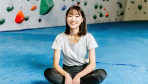 笑顔でボルダリングを休憩中の女性