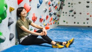 壁にもたれるボルダリング中の女性