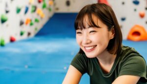 ボルダリングウォール前で微笑む女性