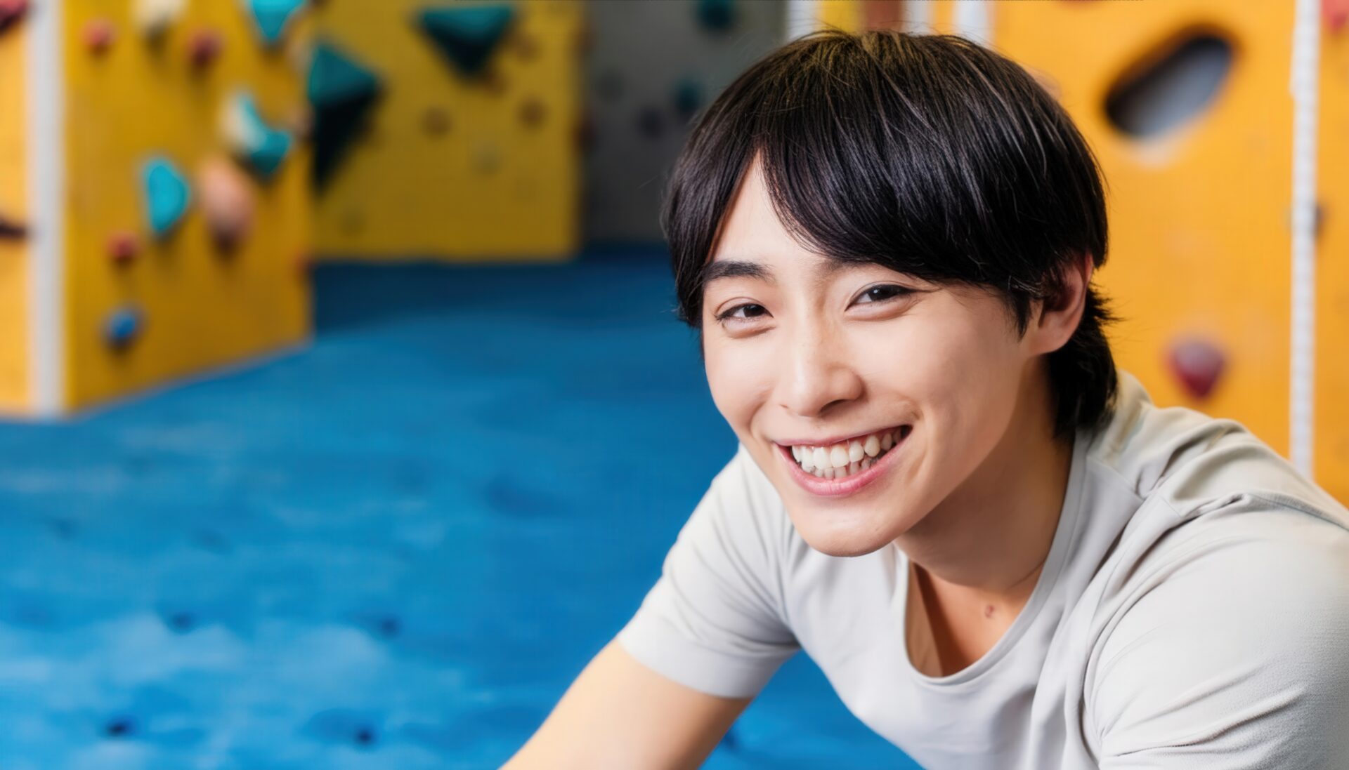 笑顔で休憩するボルダリング男性