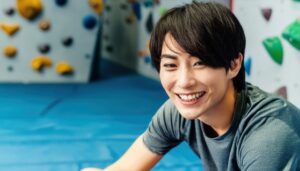 笑顔でボルダリング施設を楽しむ男性