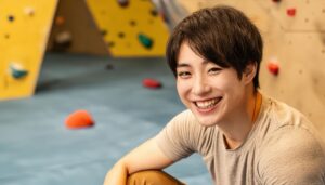 ボルダリングウォールで笑顔の男性