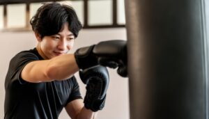 ボクシンググローブを着けてサンドバッグにパンチする男性