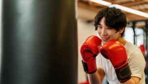 赤いグローブで構えながらサンドバッグに向かう男性