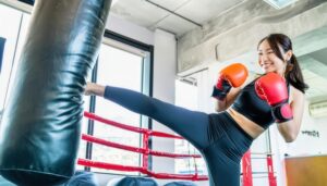サンドバッグにキックする女性