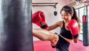 サンドバッグに笑顔でキックする女性