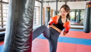 サンドバッグを蹴るトレーニング中の女性