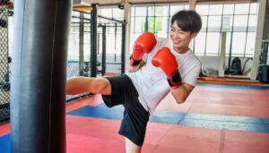 サンドバッグにキックする男性