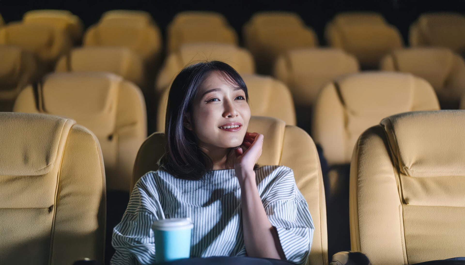 映画館で飲み物を楽しむ女性