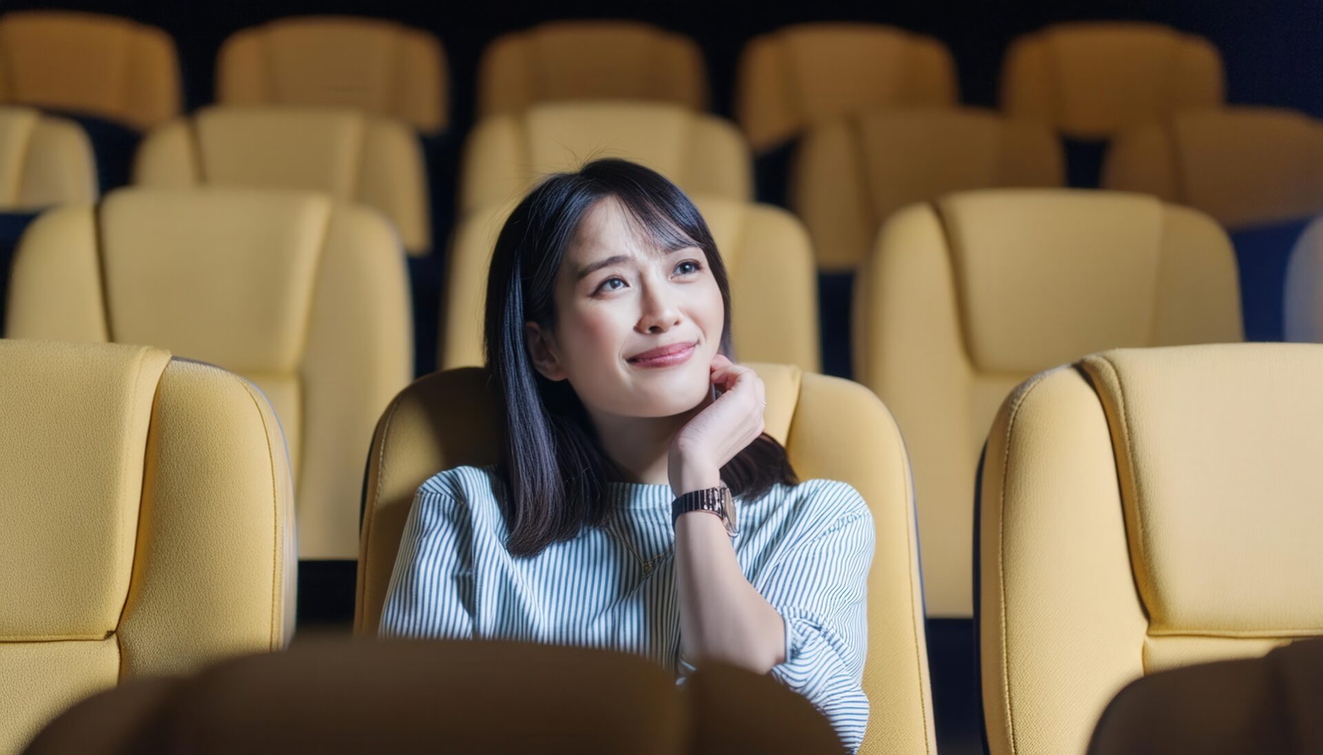 映画館で考え事をしている女性