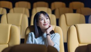 映画館で考え事をしている女性