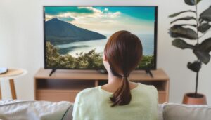 テレビで海の風景を観る女性