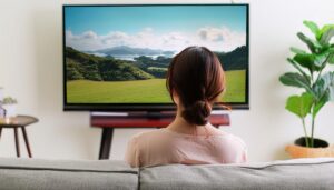 テレビで島々の風景を観る女性