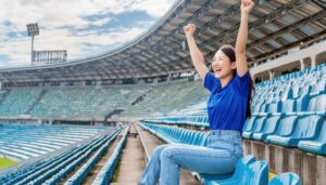 スタジアムの観客席で拳を上げる女性