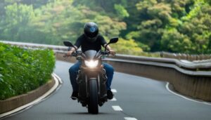 緑に囲まれた道路を走るバイク