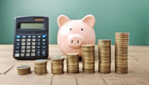 電卓とコインと貯金箱の積み上げられたイメージ