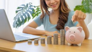 貯金箱にコインを入れる女性