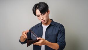 空の財布を確認する若い男性