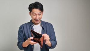 空の財布を見て驚く男性