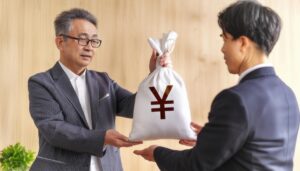 相続を渡す老年の男性とスーツ姿の息子