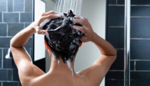 泡立てた髪を洗う後ろ姿