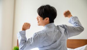 ベッドで背伸びをする若い男性2