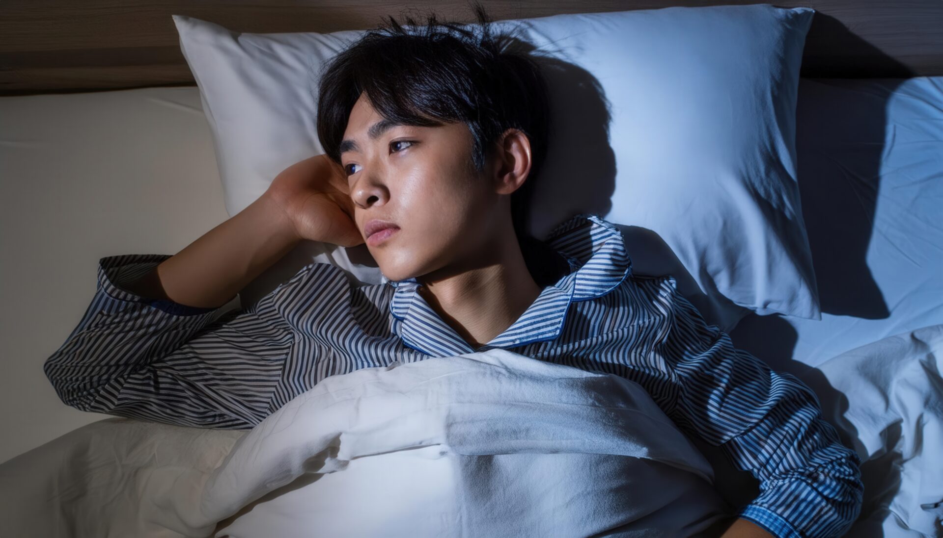 夜、考え事をする男性