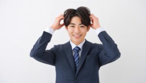 スーツ姿で髪を整える男性