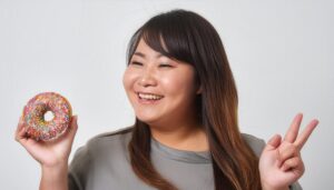 ドーナツとピースサインの女性